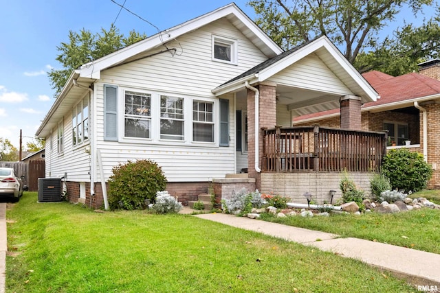 view of front of property with a front lawn, central air condition unit, and ceiling fan