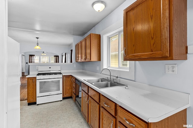 kitchen featuring decorative light fixtures, dishwasher, white range, and sink