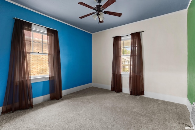 carpeted empty room featuring ornamental molding and ceiling fan