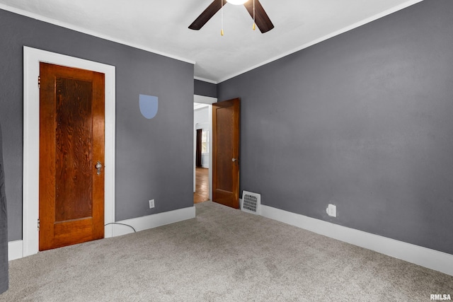 unfurnished bedroom featuring ceiling fan, crown molding, and carpet flooring