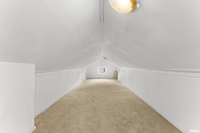 bonus room featuring light carpet, lofted ceiling, and a textured ceiling