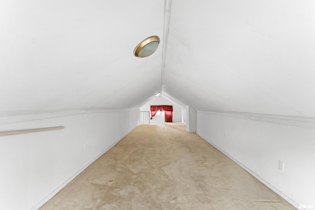 bonus room featuring vaulted ceiling and light colored carpet