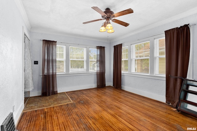 spare room featuring wood-type flooring, ornamental molding, and ceiling fan