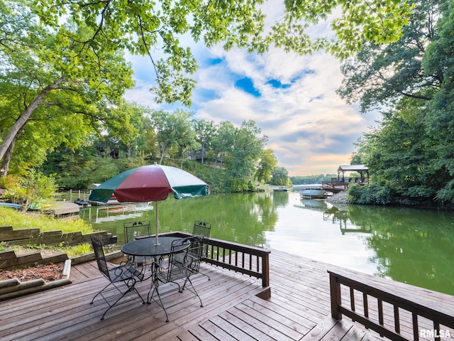 deck at dusk with a dock and a water view