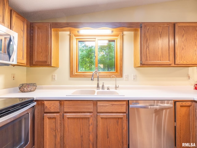 kitchen with stainless steel appliances, sink, and lofted ceiling