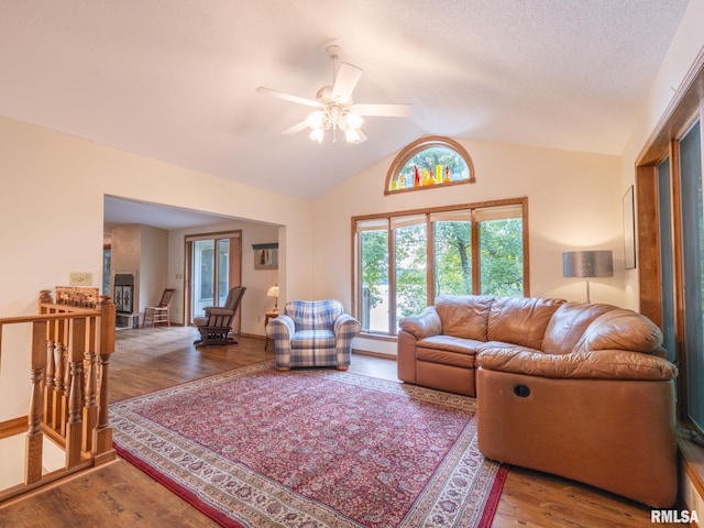 living room with wood-type flooring, vaulted ceiling, and ceiling fan