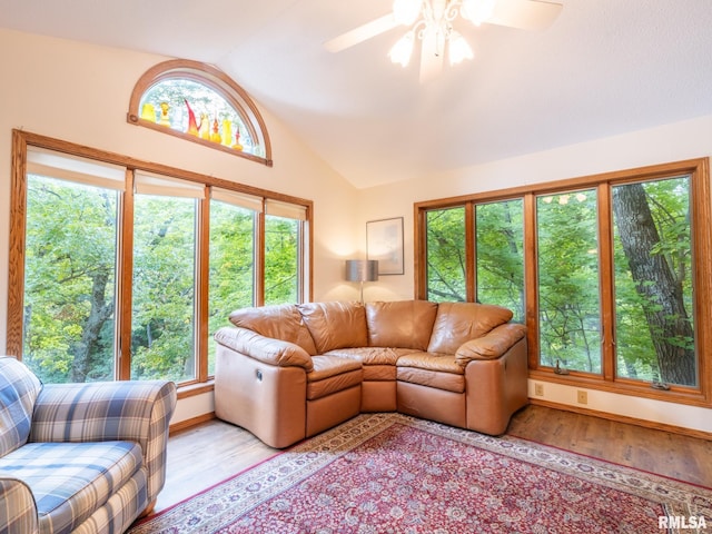 living room featuring light wood-type flooring, lofted ceiling, ceiling fan, and a wealth of natural light