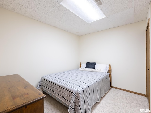 bedroom featuring light colored carpet and a paneled ceiling