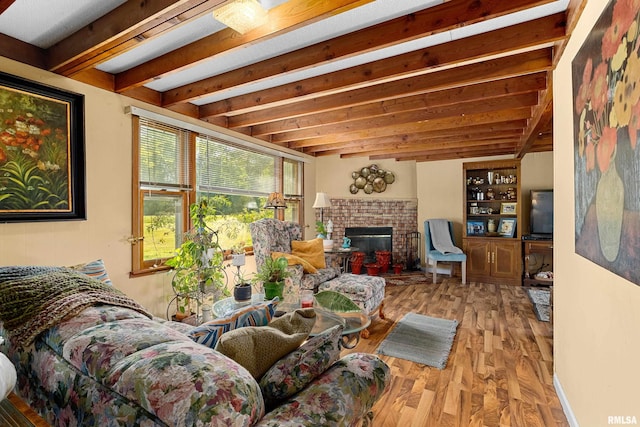 living room featuring a brick fireplace, beam ceiling, and light hardwood / wood-style floors