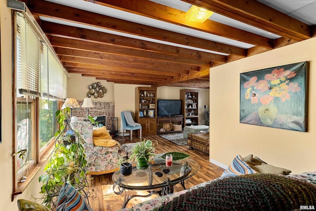 living room featuring beam ceiling, hardwood / wood-style flooring, and a fireplace