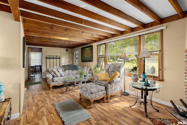 living room featuring beamed ceiling and light wood-type flooring