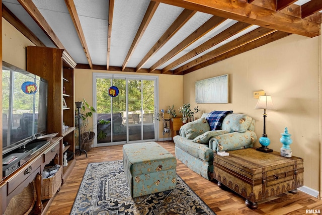 living room featuring beam ceiling and hardwood / wood-style flooring