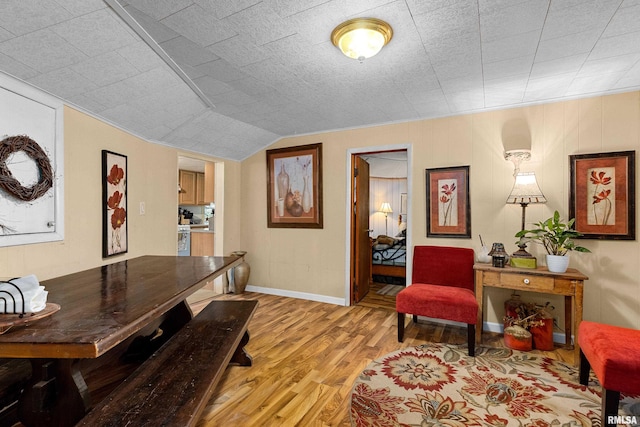 dining room featuring lofted ceiling and light hardwood / wood-style flooring