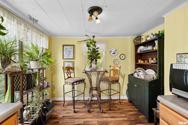 913 E Truitt Ave, Chillicothe, IL 61523 - dining space with baseboards, dark wood-style flooring, and crown molding