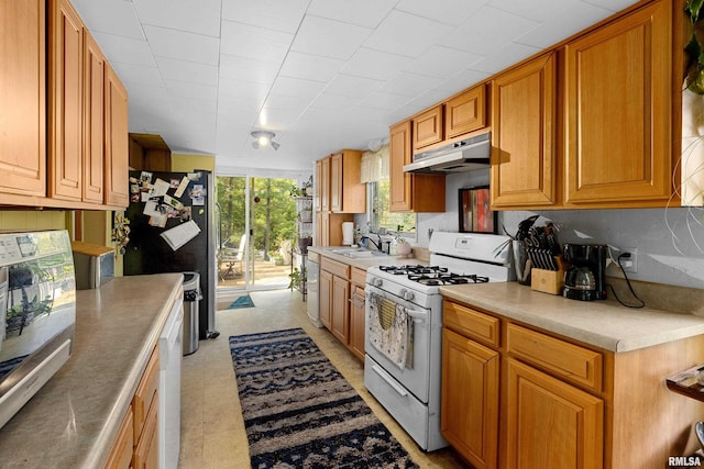 913 E Truitt Ave, Chillicothe, IL 61523 - kitchen featuring white appliances, brown cabinetry, under cabinet range hood, light countertops, and a sink