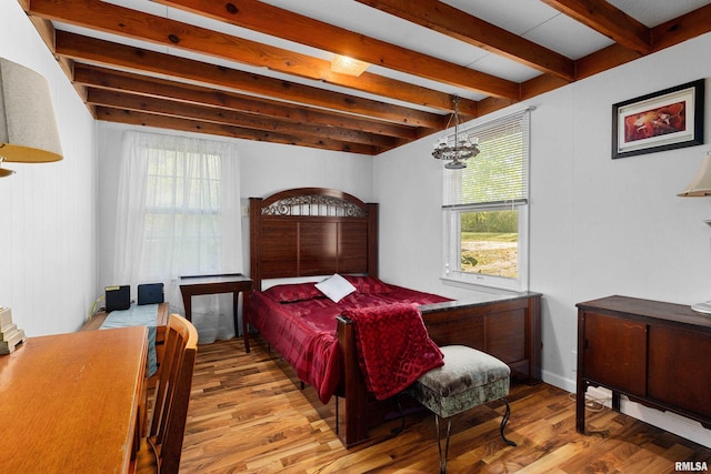 bedroom featuring light wood-type flooring, beam ceiling, and a notable chandelier