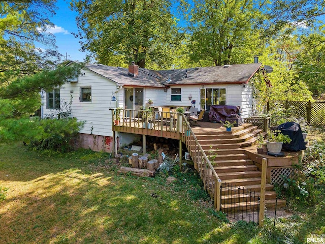 rear view of property featuring a deck and a yard