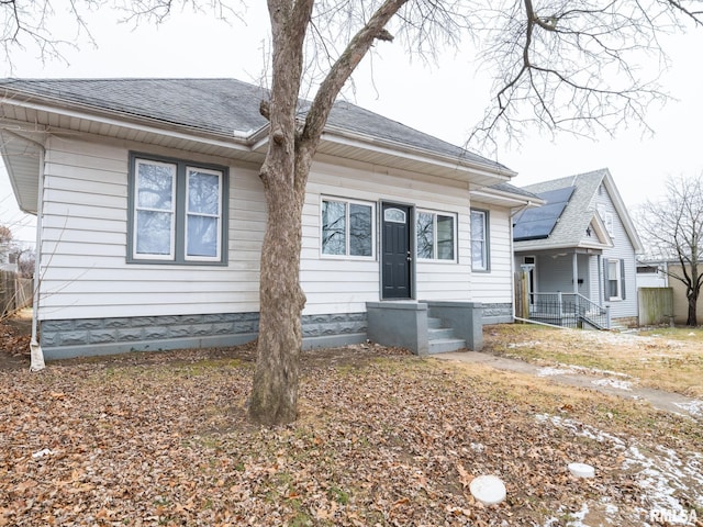 bungalow featuring roof with shingles