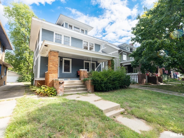 view of front of home featuring a garage, a front yard, and covered porch