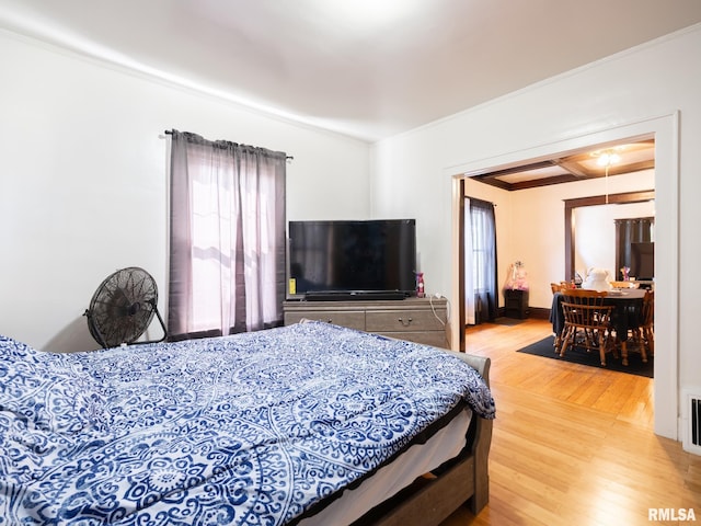 bedroom with ornamental molding and hardwood / wood-style floors