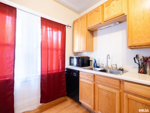 kitchen featuring sink, light hardwood / wood-style floors, and black appliances