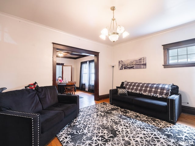 living room with an inviting chandelier, crown molding, and hardwood / wood-style floors