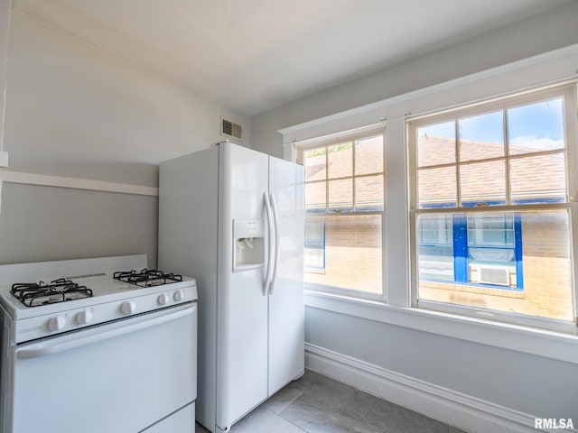 kitchen featuring cooling unit, light tile patterned floors, and white appliances