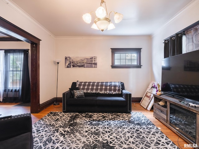 living room with ornamental molding, a notable chandelier, and light hardwood / wood-style floors