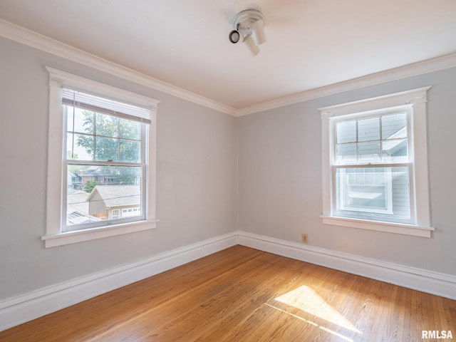 empty room with ornamental molding and hardwood / wood-style flooring