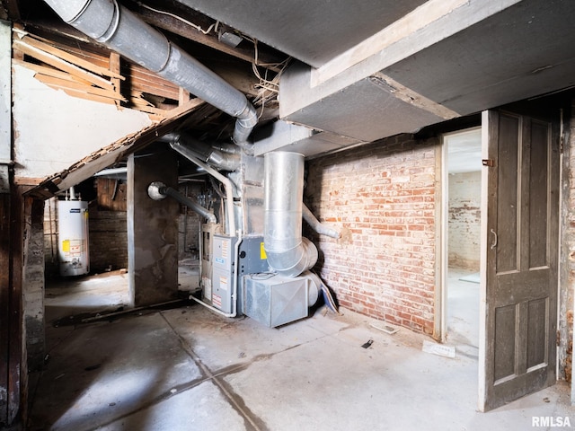 basement with gas water heater, heating unit, and brick wall