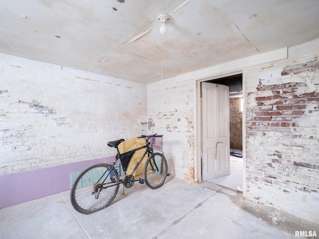 miscellaneous room with concrete floors and brick wall