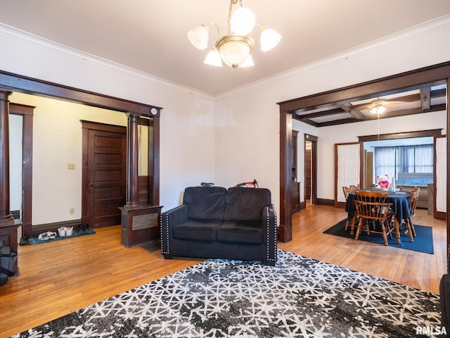 living room with ornamental molding, ceiling fan with notable chandelier, hardwood / wood-style floors, and ornate columns