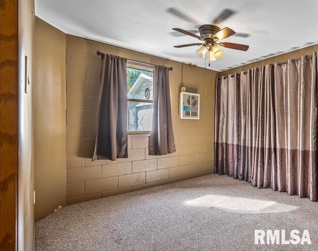 carpeted spare room featuring ceiling fan