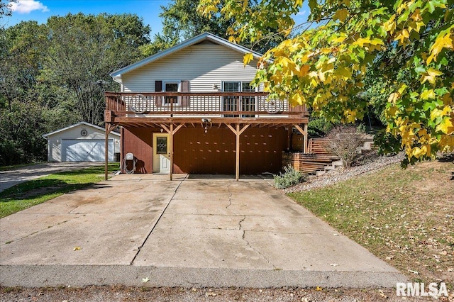 view of property featuring a garage, an outdoor structure, and a deck