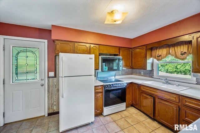 kitchen with backsplash, white appliances, sink, and light tile patterned floors