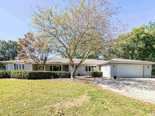 ranch-style house featuring a front lawn and a garage