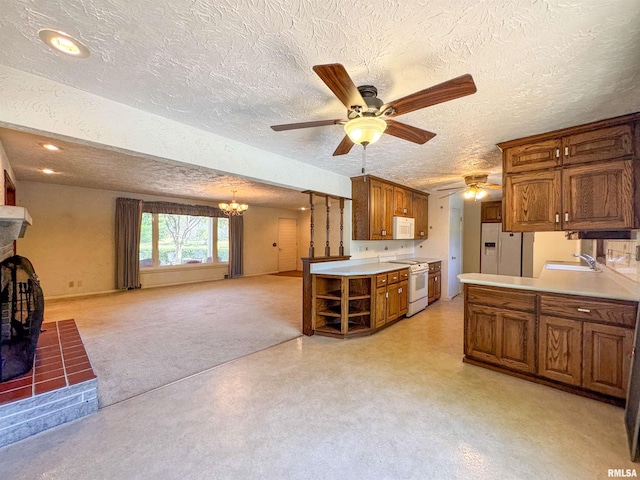 kitchen featuring ceiling fan with notable chandelier, white appliances, and a textured ceiling