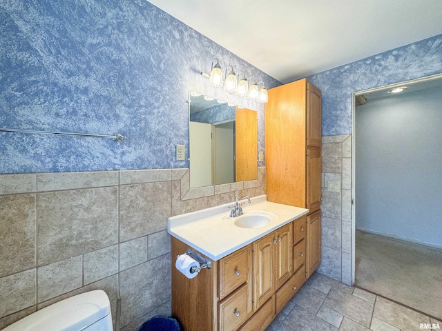 bathroom with tile walls, vanity, and toilet