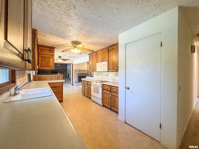 kitchen featuring a textured ceiling, backsplash, sink, and white appliances