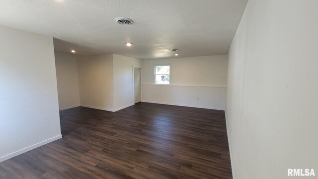 empty room with dark hardwood / wood-style flooring