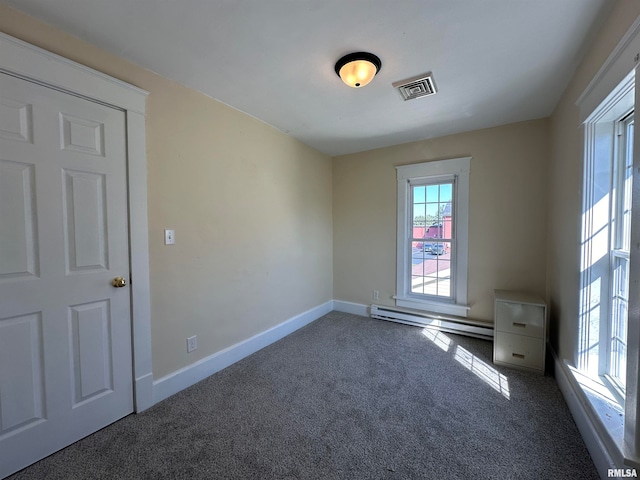 spare room with dark carpet and baseboard heating