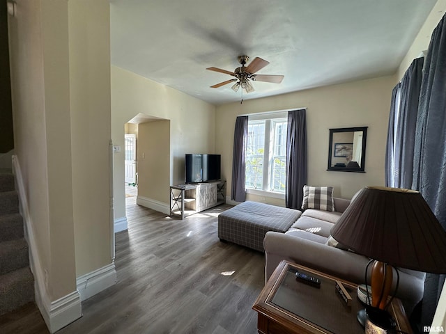 living room with ceiling fan and dark hardwood / wood-style flooring