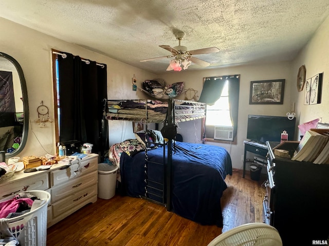 bedroom with ceiling fan, cooling unit, a textured ceiling, and dark wood-type flooring