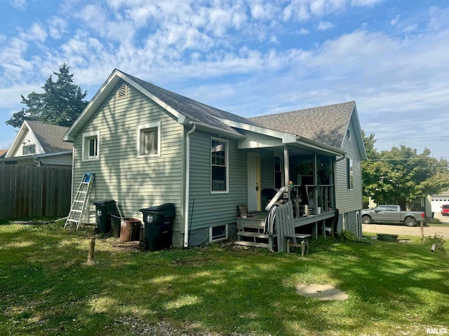 rear view of property with a yard and covered porch