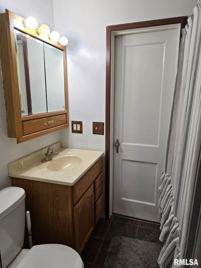 bathroom with tile patterned flooring, vanity, and toilet