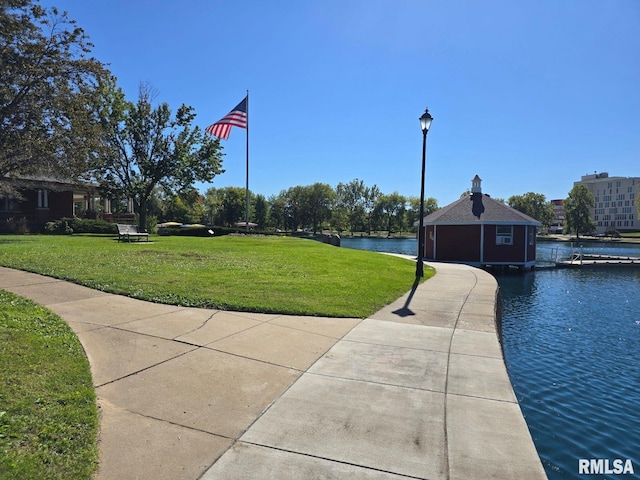 surrounding community with a yard and a water view