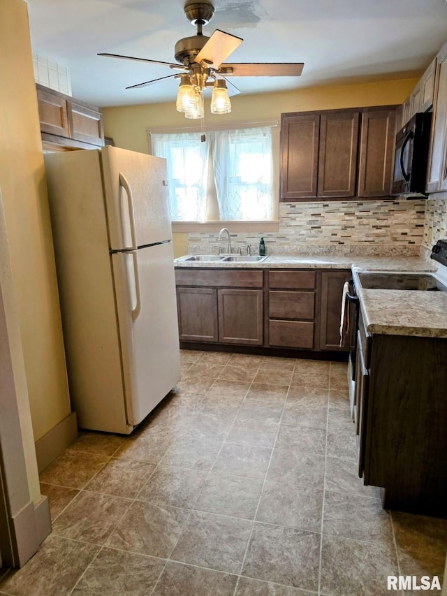 kitchen featuring decorative backsplash, white fridge, electric stove, and sink