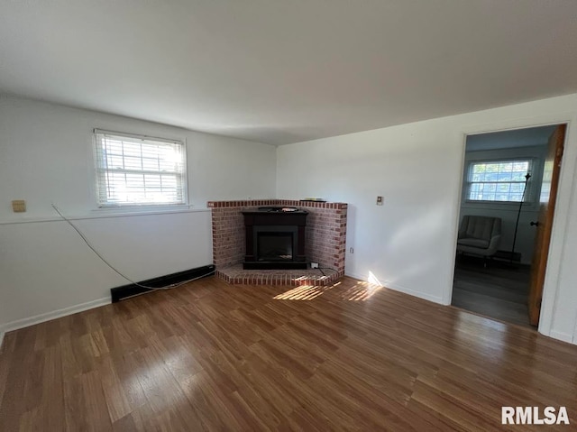 unfurnished living room featuring a wealth of natural light, a fireplace, and hardwood / wood-style floors