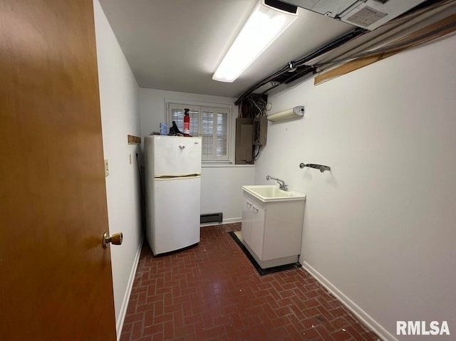 washroom with sink and a baseboard heating unit