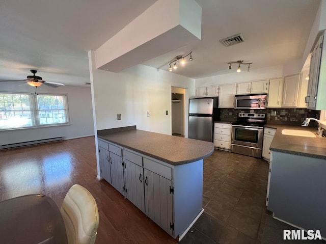 kitchen with dark hardwood / wood-style floors, sink, white cabinetry, backsplash, and appliances with stainless steel finishes